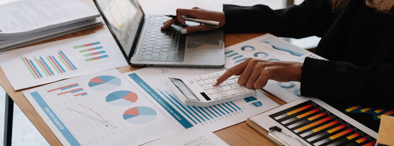 Een ondernemer die tussen stapels papierwerk en administratie door zijn bedrijf probeert te overzien