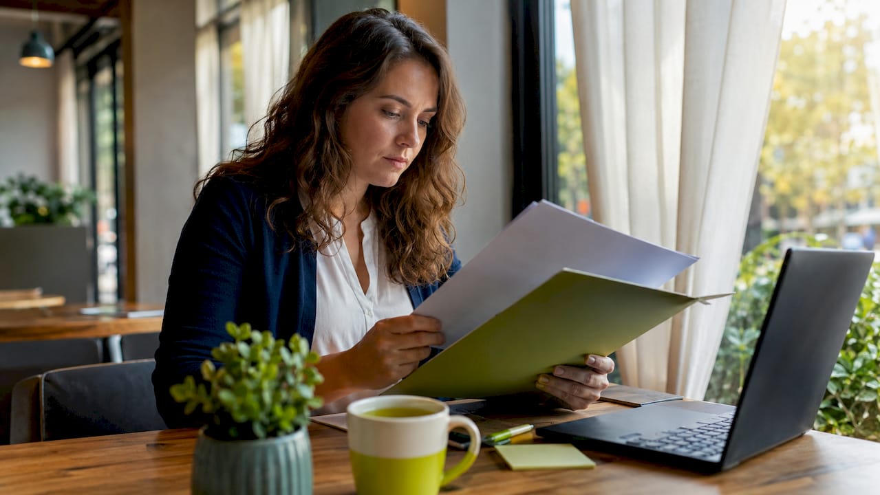 Een zzp'er bekijkt aan zijn bureau financiële stukken die onder de bewaarplicht vallen