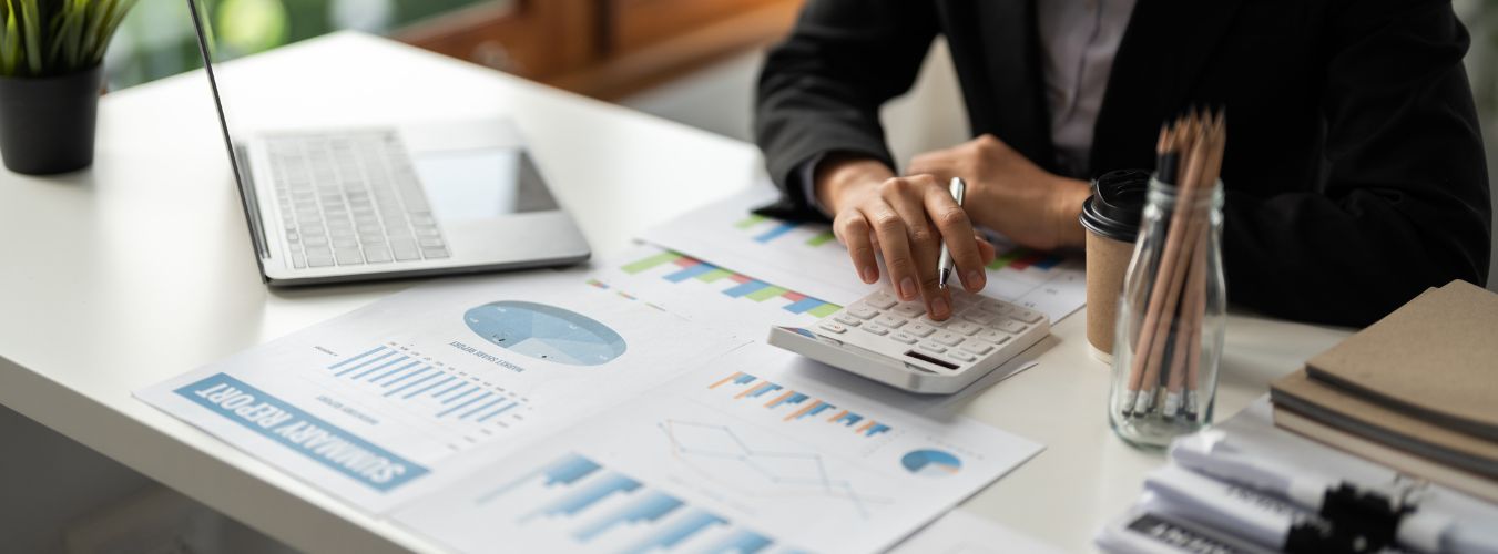 Close-up van een bureau met financiële rapporten, grafieken en een rekenmachine